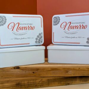 Petites boîtes rectangulaires avec couvercle blanc illustré du logo Navarro et dentelles provençales.